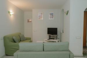 a living room with a couch and a television at gardeniapartment in Minori