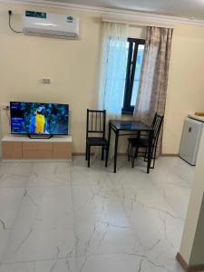 a living room with a television and a table and chairs at Erevanyan House in Pʼarakʼar