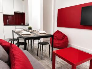 a dining room with a table and a red couch at Smart-Tech Plaza Apartment in Salamanca