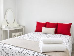 a bedroom with a bed with red pillows and a mirror at Smart-Tech Plaza Apartment in Salamanca