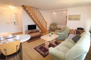 a living room with a couch and a table at Haus Koppelweg FW-Fisch in Ahrenshoop