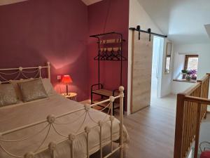 a bedroom with a bed and a red wall at Lazy Days Gite in Rancon