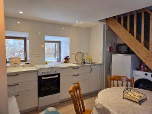 a kitchen with white cabinets and a staircase at Lazy Days Gite in Rancon +14 photos