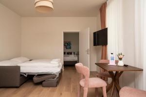 a bedroom with a bed and a table and chairs at Miki Stays - 700m zum Ring in Vienna