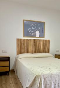 a bedroom with a bed and a picture on the wall at Golondrinas Verdes in Huelva