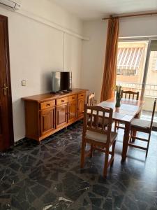 a dining room with a table and a television on a cabinet at Apartamentos turisticos los baños in Fortuna