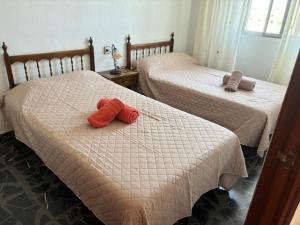two beds with red stuffed animals on them in a room at Apartamentos turisticos los baños in Fortuna