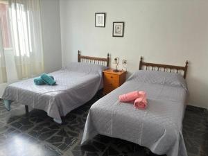 two beds in a bedroom with towels on them at Apartamentos turisticos los baños in Fortuna