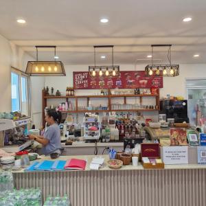 a woman standing behind the counter of a store at River View Villas in Vang Vieng