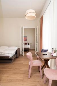 a bedroom with a bed and a table and chairs at Miki Stays - 700m zum Ring in Vienna