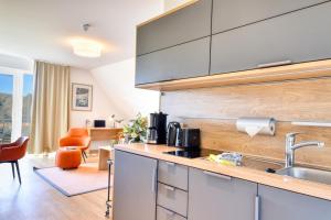 a kitchen with a sink and a counter top at Ferienwohnung Buntspecht 31 im Wreecher Idyll Rügen by ruyastay in Putbus +7 photos