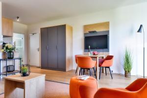 a living room with orange chairs and a table at Ferienwohnung Buntspecht 31 im Wreecher Idyll Rügen by ruyastay in Putbus