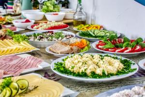 a table with many plates of food on it at Baltic Sand - Apartamenty I Pokoje Władysławowo in Władysławowo