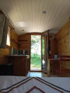 a room with a large sliding glass door in a cabin at La Roulotte by Maison Maliga in Saint-Pierre-de-Curtille