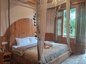 a bedroom with a canopy bed with a teddy bear on it at Bhindeshi Tara Stays Jibhi Mihar in Jibhi