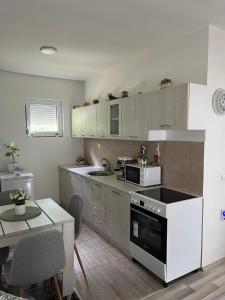 a kitchen with a stove and a microwave at Sumski Kutak in Valjevo +12 photos