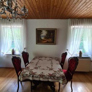a dining room with a table and chairs and windows at Haus Nummer 7 in Manderscheid