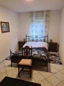 a bedroom with a bed and a chair and a window at Haus Nummer 7 in Manderscheid