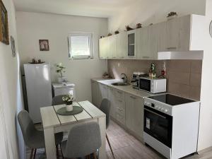 a small kitchen with a table and a refrigerator at Sumski Kutak in Valjevo