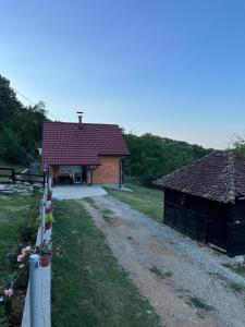 a house with a dirt road next to a building at Sumski Kutak in Valjevo