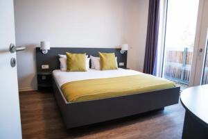 a bedroom with a large bed with yellow sheets at Das ELB Hotel & Restaurant in Magdeburg