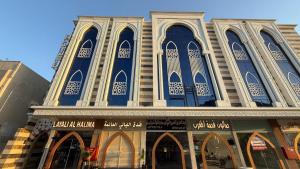a large building with blue windows on a street at فندق الليالي الحالمة in Medina