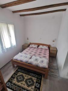 a bedroom with a bed in a room with rugs at Smestaj kod Sneze in Dojkinci