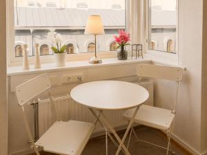 a table and two chairs in a room with a window at Avenyn Hostel, former Le Mat in Gothenburg