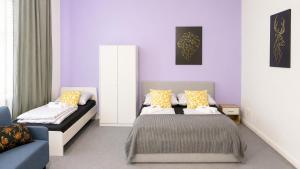 a bedroom with purple walls and a bed and a couch at Koblenz Corner Rooms in Koblenz