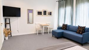a living room with a blue couch and a table at Koblenz Corner Rooms in Koblenz