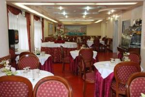 a restaurant with white tables and chairs with pink table cloth at Hotel Burchiello in Mira