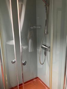 a shower in a bathroom with a person taking a picture at Lejlighed i Soldalen in Sindal