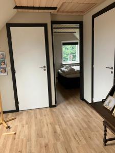 a room with two doors and a bedroom with a bed at Lejlighed i Soldalen in Sindal