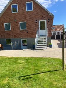 a brick house with a staircase in front of it at Lejlighed i Soldalen in Sindal