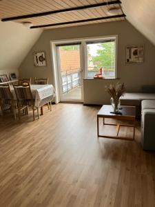 a living room with a couch and a table at Lejlighed i Soldalen in Sindal +2 photos