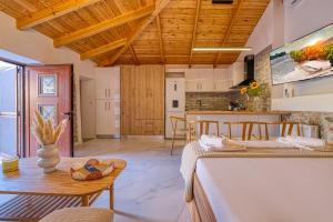 a kitchen and living room with two beds and a table at Thymele Stone House in Lygourio