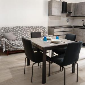 a dining room with a table and chairs and a couch at Brezza marina in Alghero