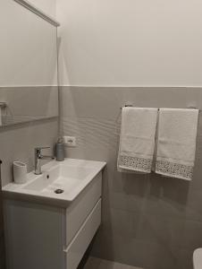 a bathroom with a sink and a mirror and towels at Brezza marina in Alghero