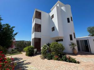 a white building with some plants in front of it at Vila Jeti in Ksamil