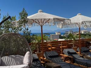 a group of chairs and umbrellas on a balcony at Vila Jeti in Ksamil