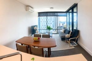 a living room with a table and chairs and a dining room at Stadium View Retreat at Olympic Park in Sydney