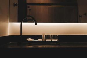 a bathroom sink with two glasses on a counter at Pousada Murano in Campos do Jordão +80 photos