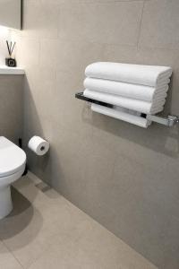 a bathroom with a pile of towels on a wall at Stadium View Retreat at Olympic Park in Sydney +13 photos