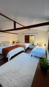 a large bedroom with two beds and a window at Zen Spa Caraíva in Caraíva