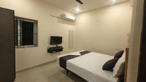 a bedroom with a bed and a tv in it at Melody Stays Inn in Chennai