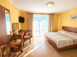 a bedroom with a bed and a desk and a television at Willa Julia in Rewal