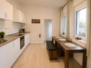 a kitchen with white cabinets and a wooden table at Koblenz Corner Rooms in Koblenz
