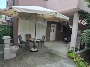a patio with a table and chairs under an umbrella at Alfi apartments 1 in Belgrade