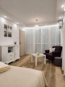 a bedroom with a bed and a couch and a table at Alfi apartments 1 in Belgrade