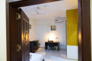 a room with a desk and a room with a door at Maya Lodge in Accra